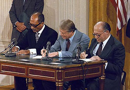 President Jimmy Carter and leaders of Egypt and Israel signing documents