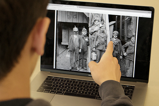 Max pointing to a photo of child mine workers