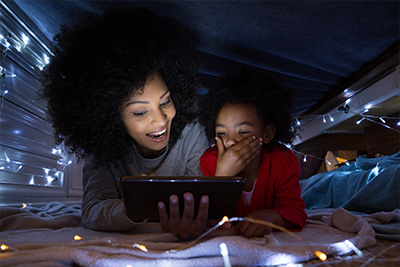 – mother and two young children look at a digital tablet