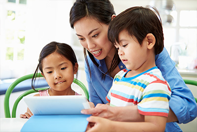 – mother and two young children look at a digital tablet